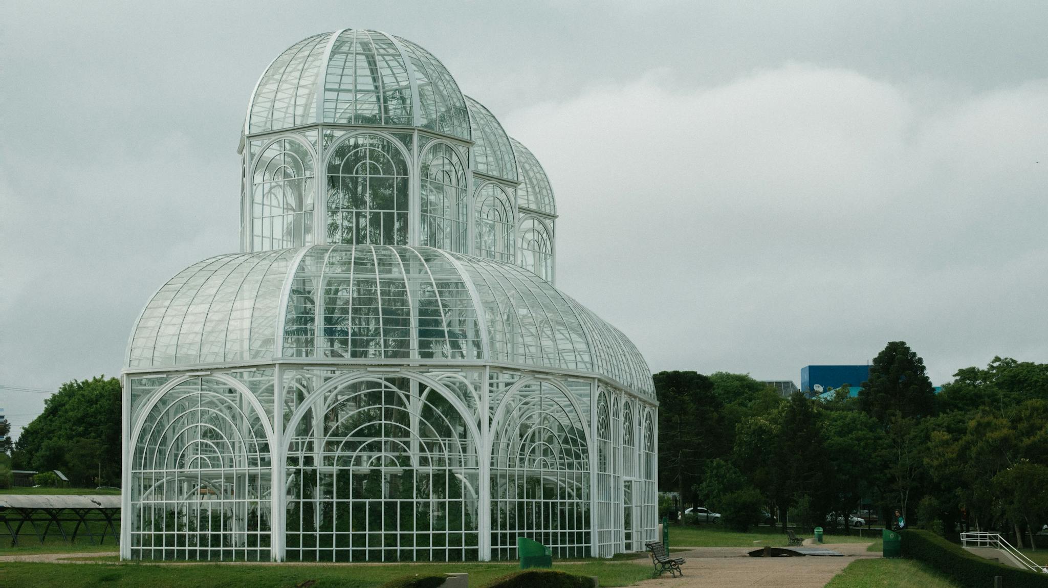 Wide Angle Shot Of White Greenhouse In The Middle of A Park